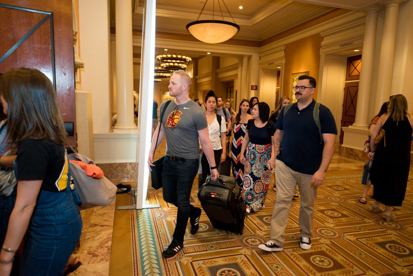Employees arriving with luggage through a Caesars Palace corridor
