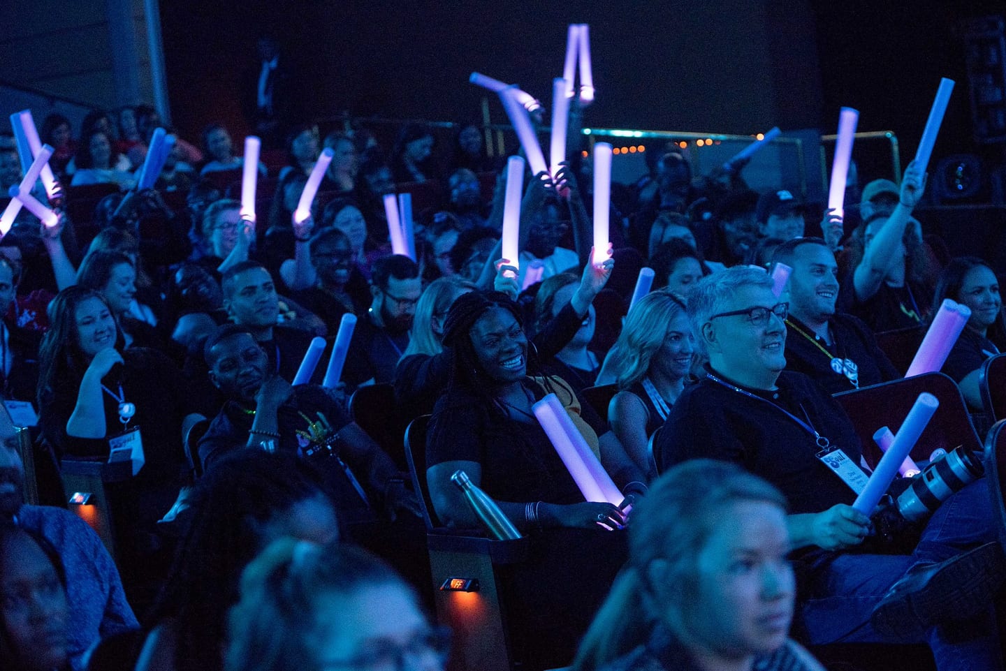 Employees holding glow sticks aloft in the darkened Colosseum