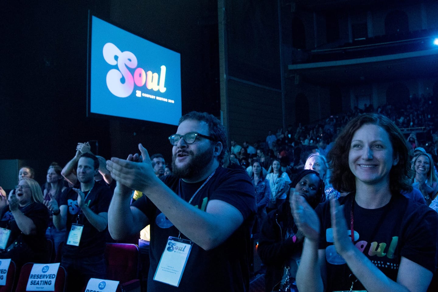 Two employees in SOUL t-shirts applauding in the audience