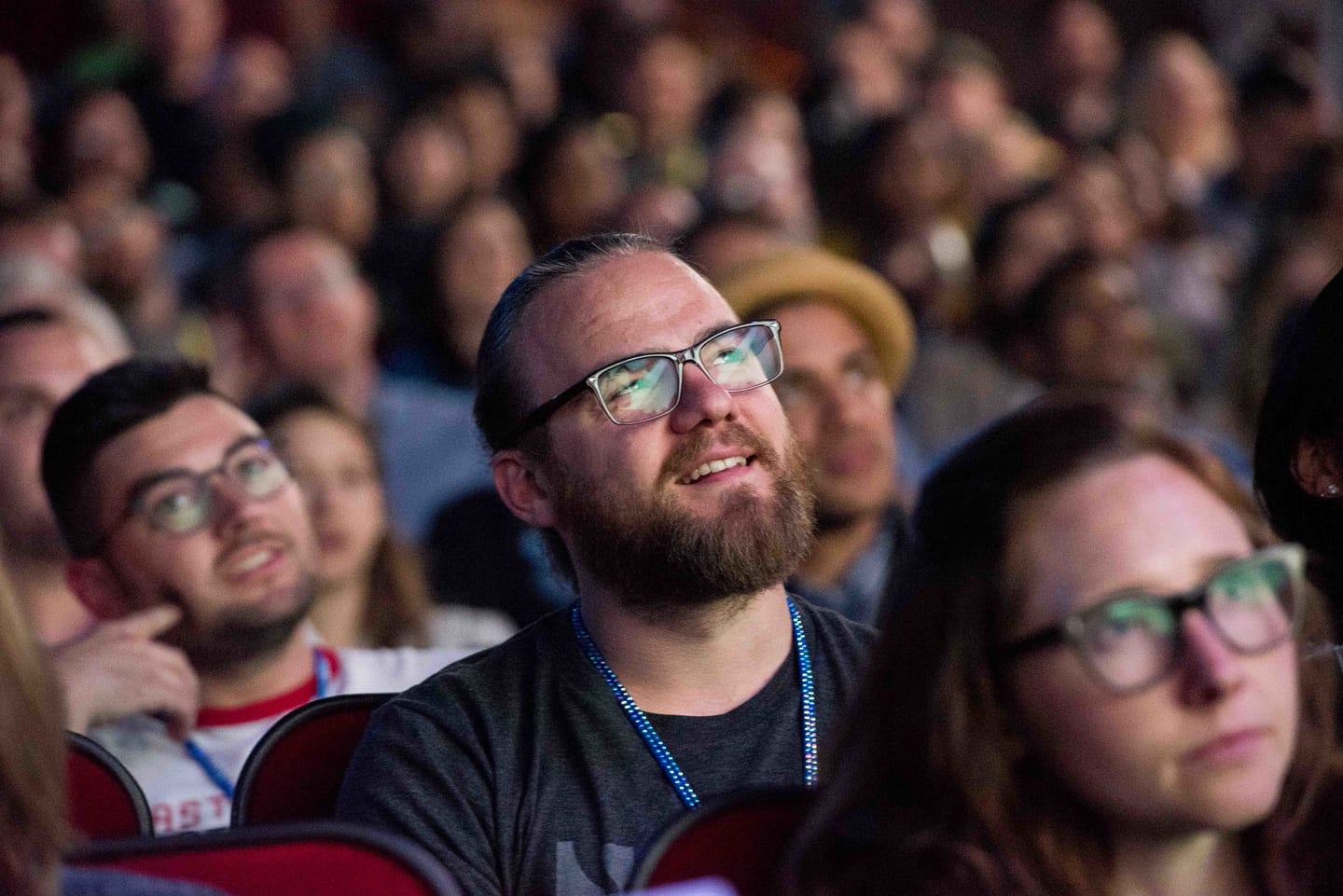 A close frame of an employee smiling among the seated audience