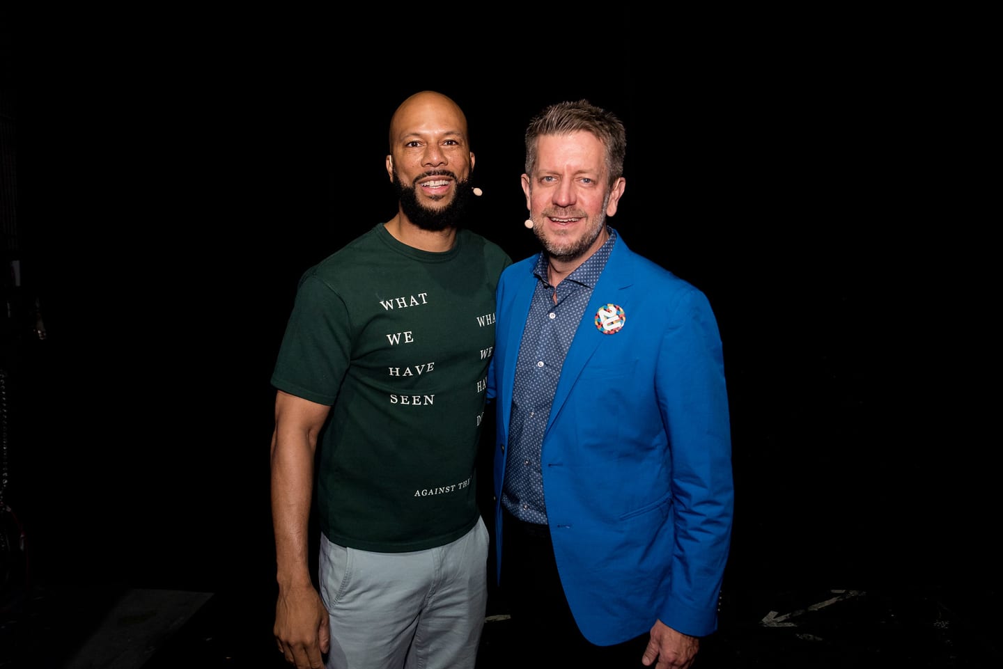 Common and 2U co-founder Chip Paucek standing together against a black backdrop backstage at the Colosseum