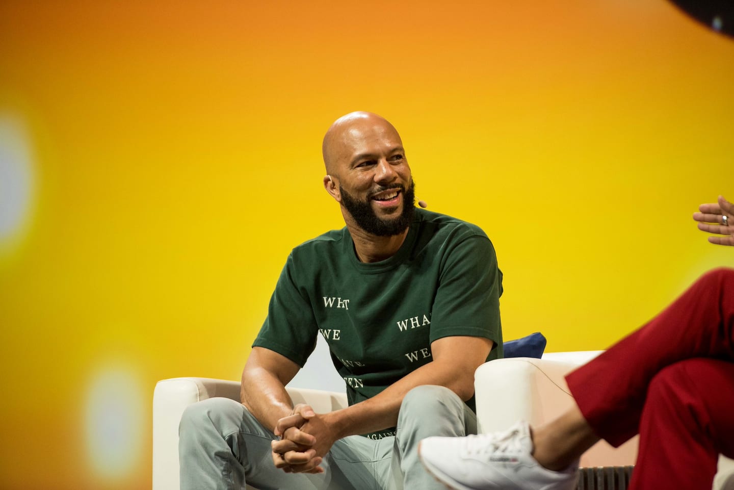 Common seated and listening during a fireside conversation on stage at the 2U company meeting