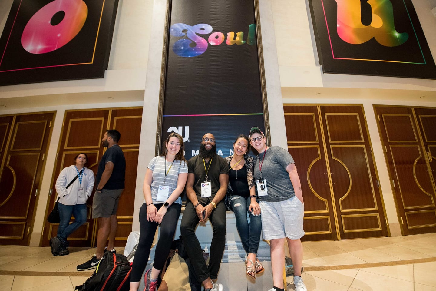 A group of employees seated and standing in front of the SOUL signage outside the theatre