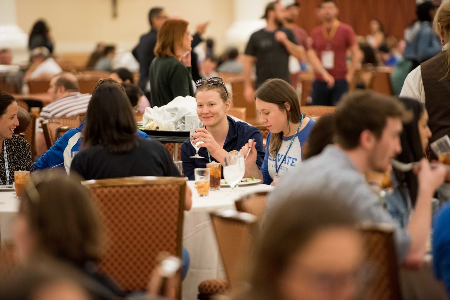 Employees eating and talking at banquet tables during the midday break