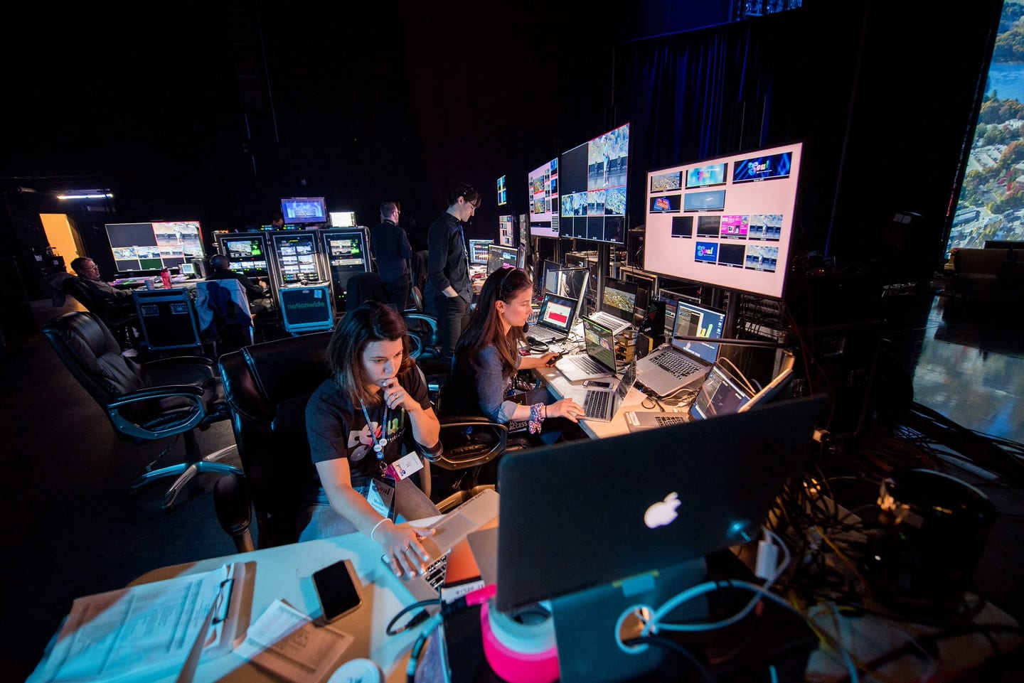 Crew working at the production desk with monitors and laptops during the company meeting
