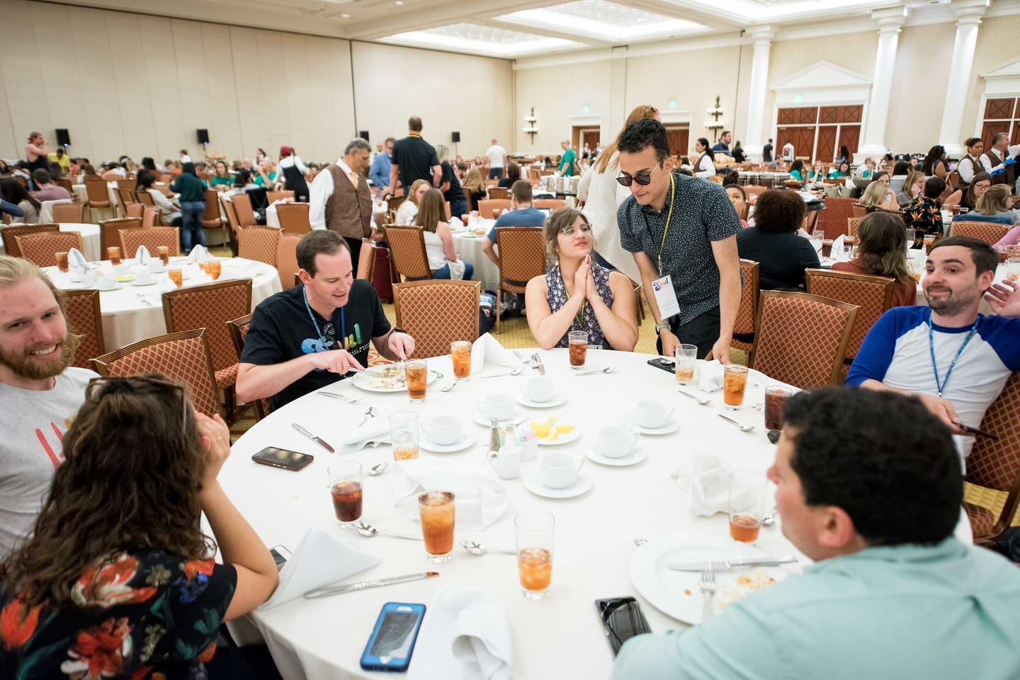 Employees talking around a round banquet table during the company meeting
