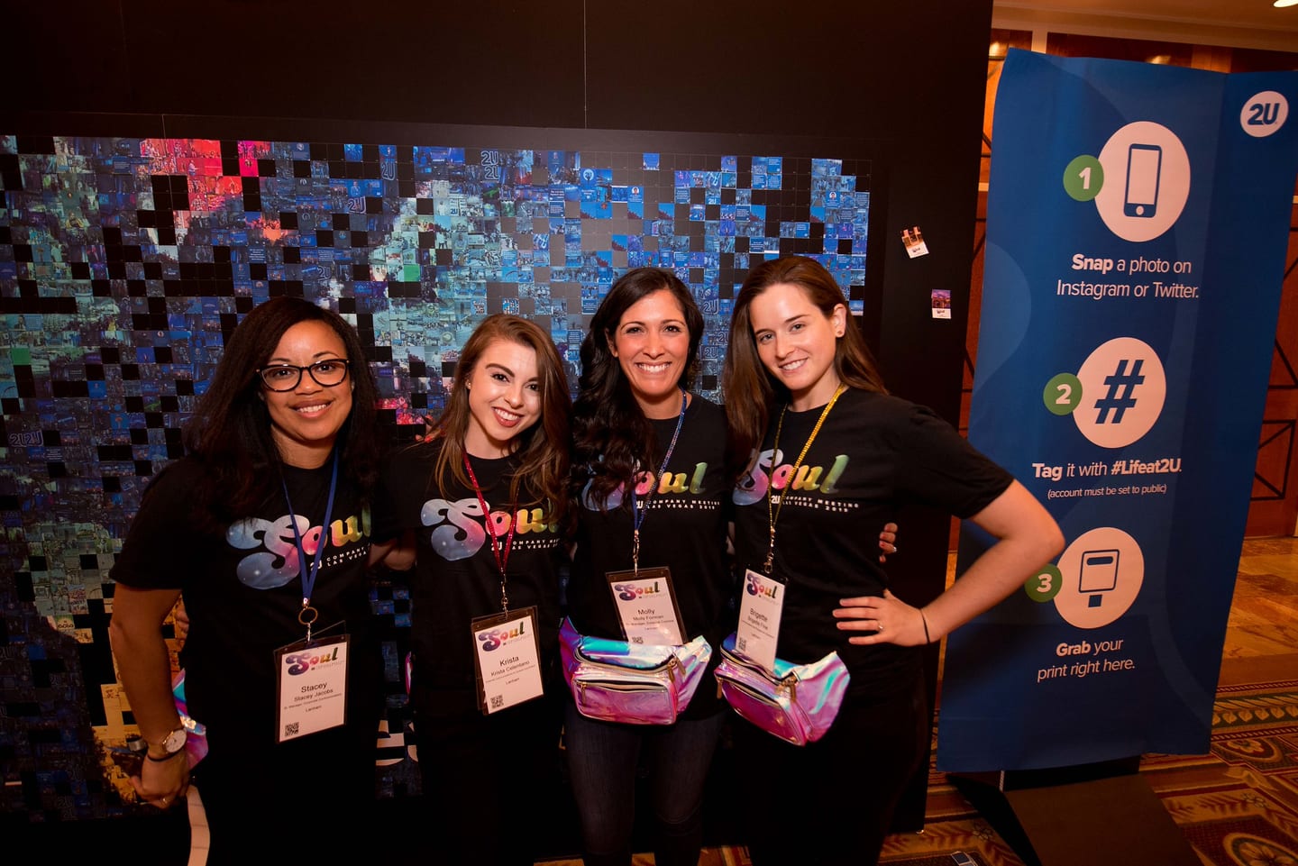 Four SOUL crew members in branded t-shirts standing beside a social-media instruction banner