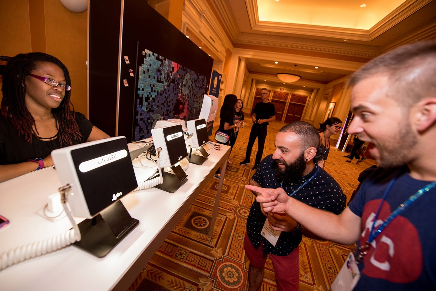 Employees laughing at a row of tablet check-in stations in a Caesars Palace ballroom