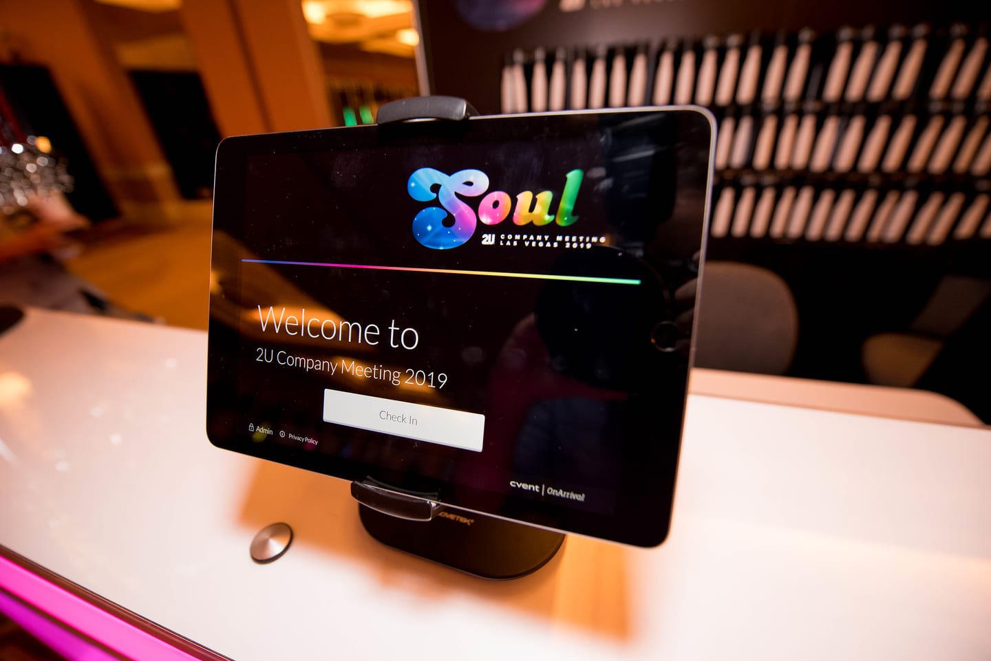 A tablet on a check-in table reading Welcome to 2U Company Meeting 2019