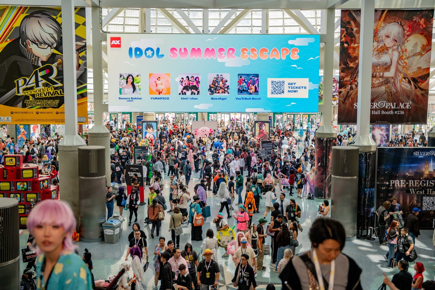 A massive crowd filling the Anime Expo show floor beneath convention banners at the Los Angeles Convention Center