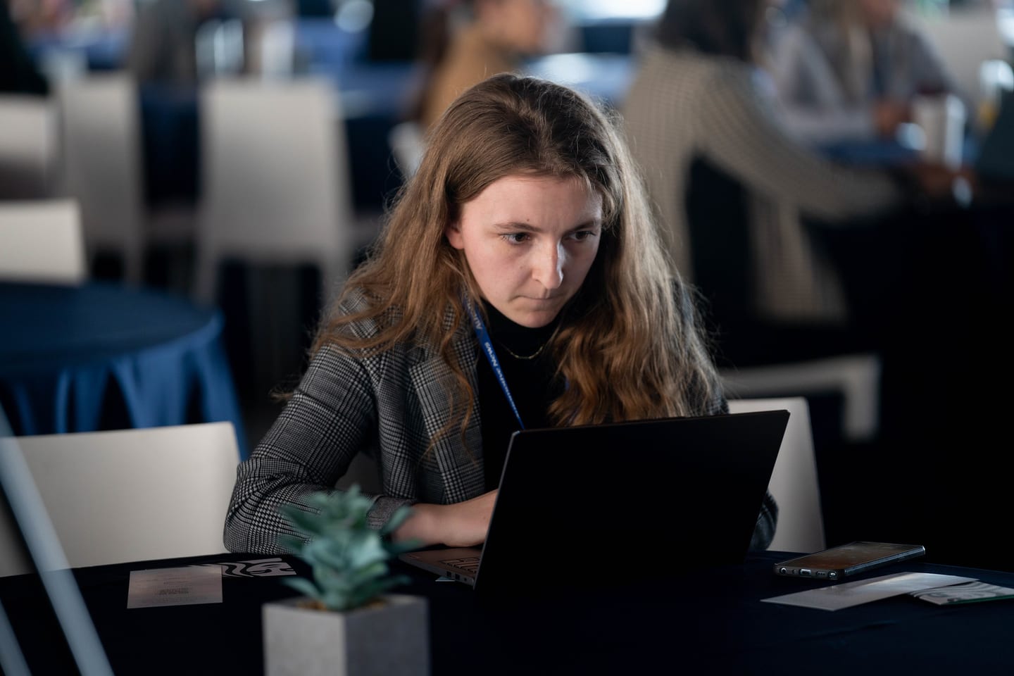 An attendee working on a laptop at a table during the program at the Automotive News Congress: Los Angeles, City Market Social House