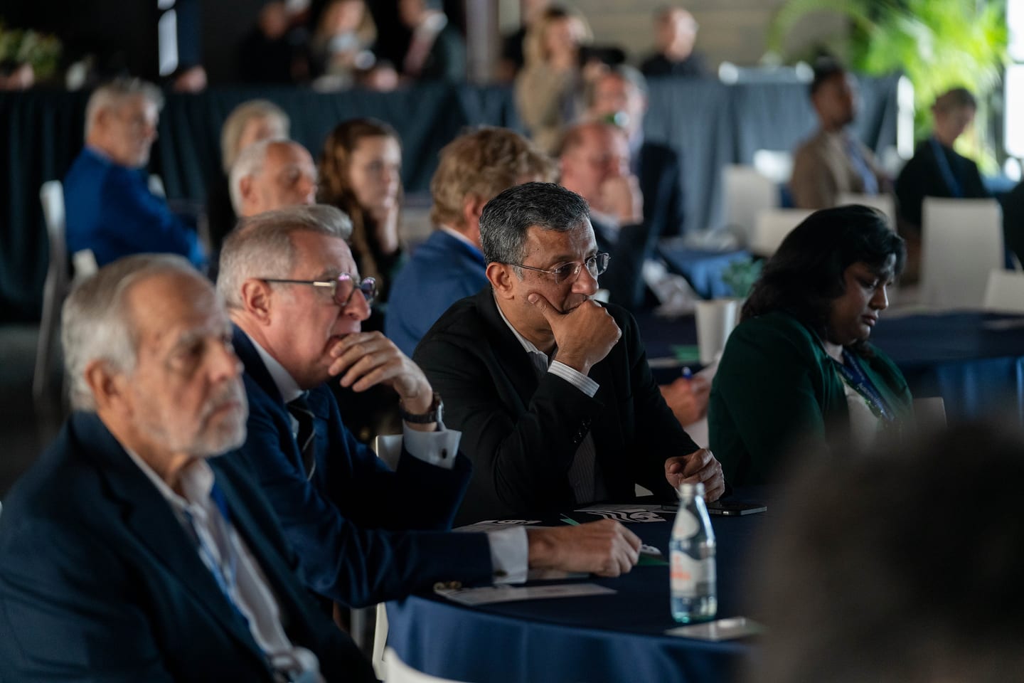 Attendees seated at round tables listening to a stage session at the Automotive News Congress: Los Angeles, City Market Social House