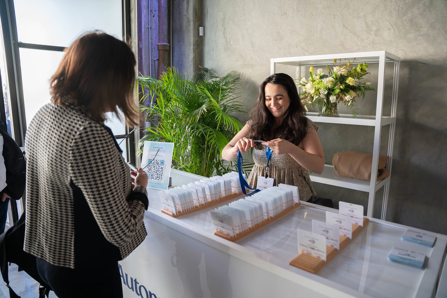 Staff handing out name badges and lanyards at the registration table at the Automotive News Congress: Los Angeles, City Market Social House