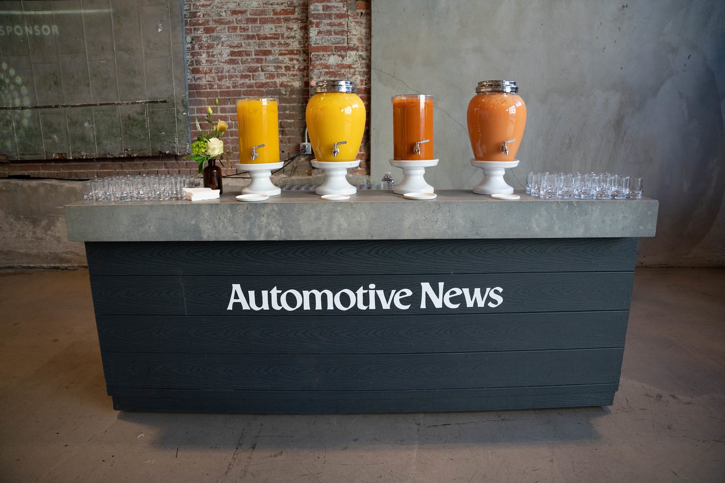 A bar front branded Automotive News, set with juice carafes before the morning reception at the Automotive News Congress: Los Angeles, City Market Social House