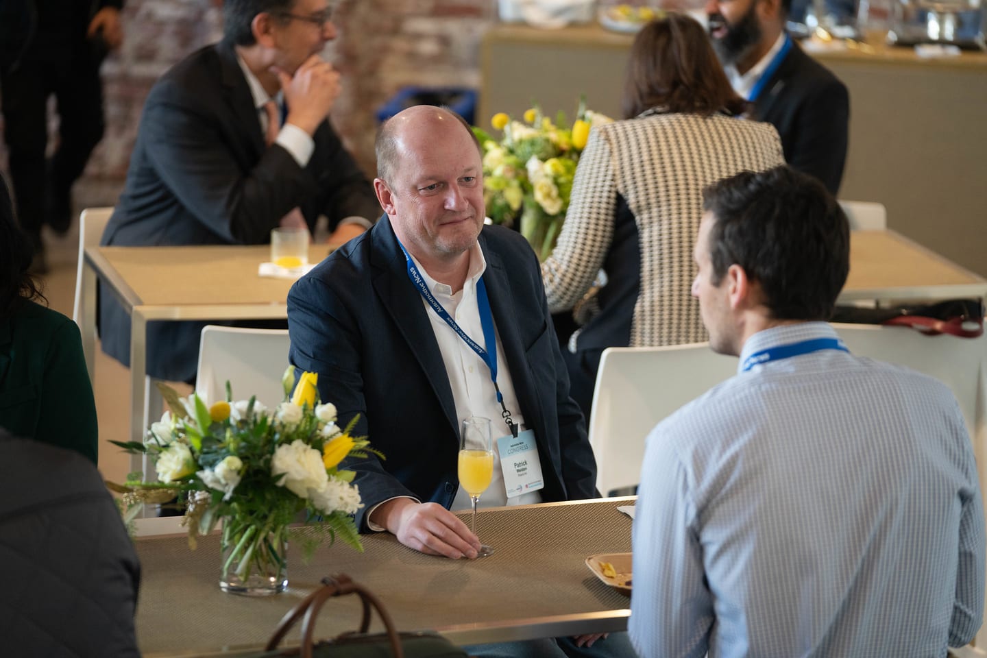 Attendees talking across a breakfast table before the program began at the Automotive News Congress: Los Angeles, City Market Social House
