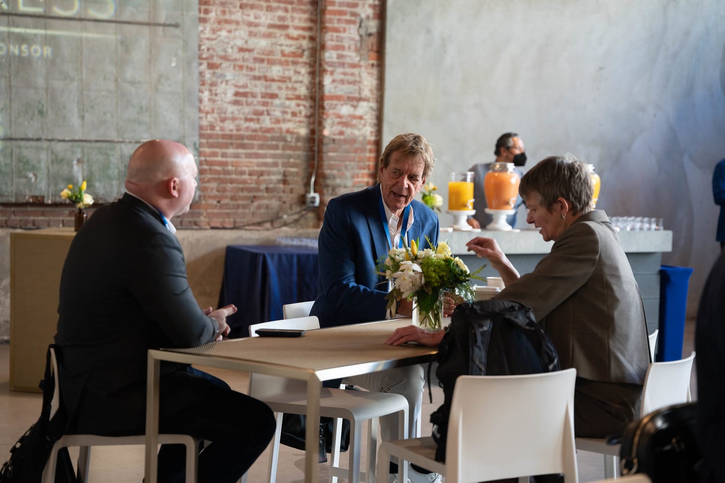 Three attendees talking over breakfast at a high table at the Automotive News Congress: Los Angeles, City Market Social House