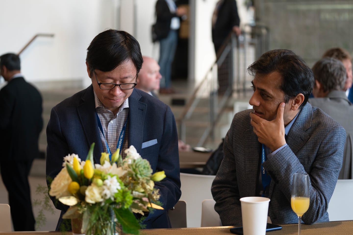 Two attendees in conversation over coffee and juice at a breakfast table at the Automotive News Congress: Los Angeles, City Market Social House