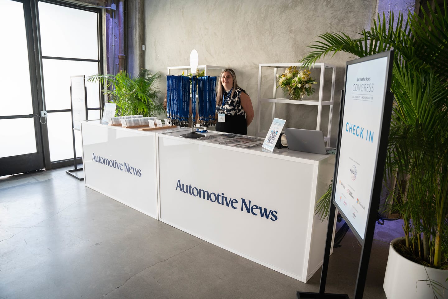 A wide view of the Automotive News branded check-in desk and Check In signage before doors at the Automotive News Congress: Los Angeles, City Market Social House