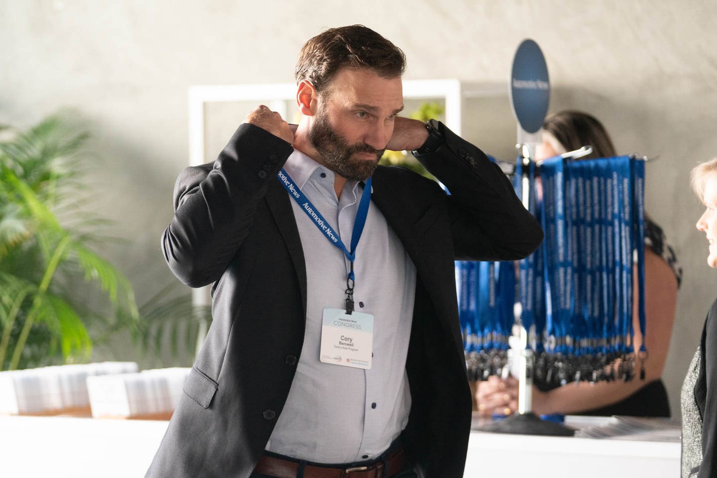 An attendee putting on a conference lanyard at the badge table at the Automotive News Congress: Los Angeles, City Market Social House