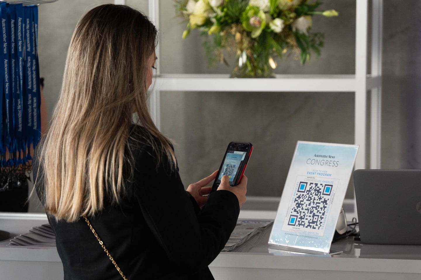 An attendee scanning a QR code with a phone to open the event program at the Automotive News Congress: Los Angeles, City Market Social House