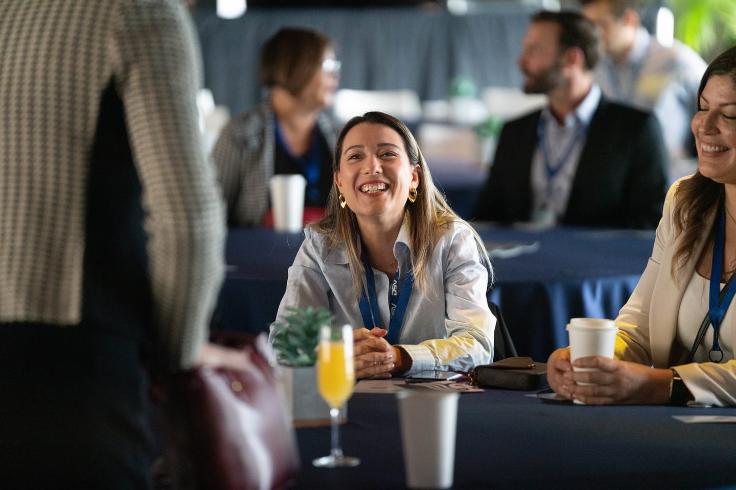 Attendees laughing together at a table during the morning reception at the Automotive News Congress: Los Angeles, City Market Social House