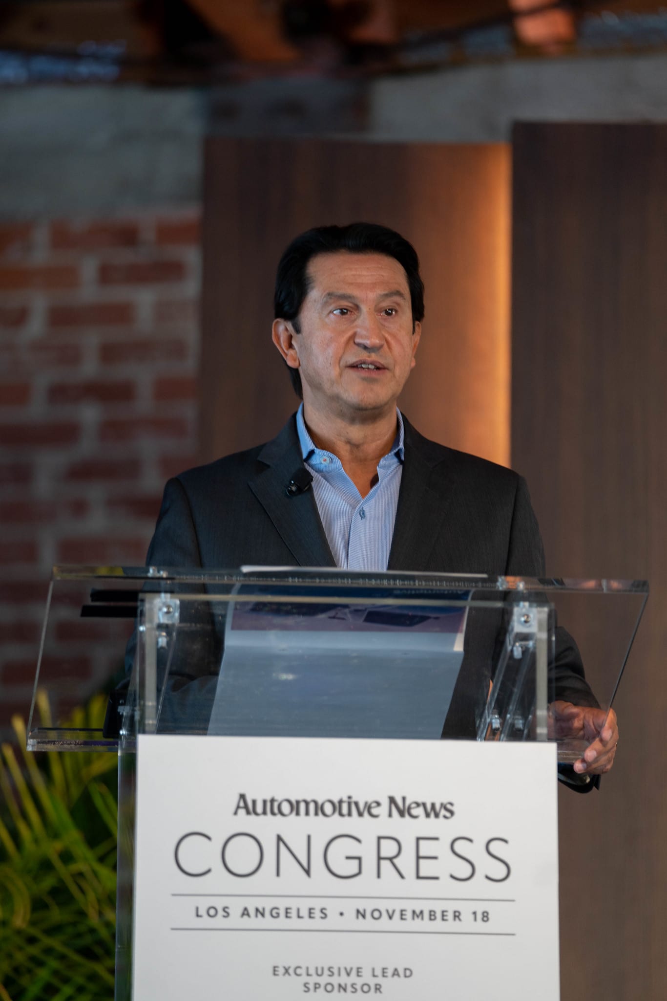 A speaker at the lectern beneath the Congress branding at the Automotive News Congress: Los Angeles, City Market Social House