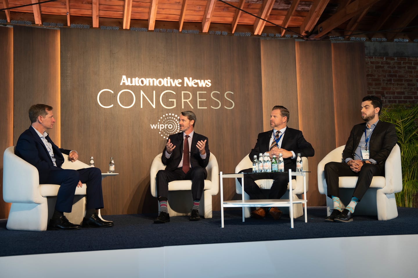Four panellists seated on stage beneath the illuminated Automotive News Congress and Wipro branding at the Automotive News Congress: Los Angeles, City Market Social House