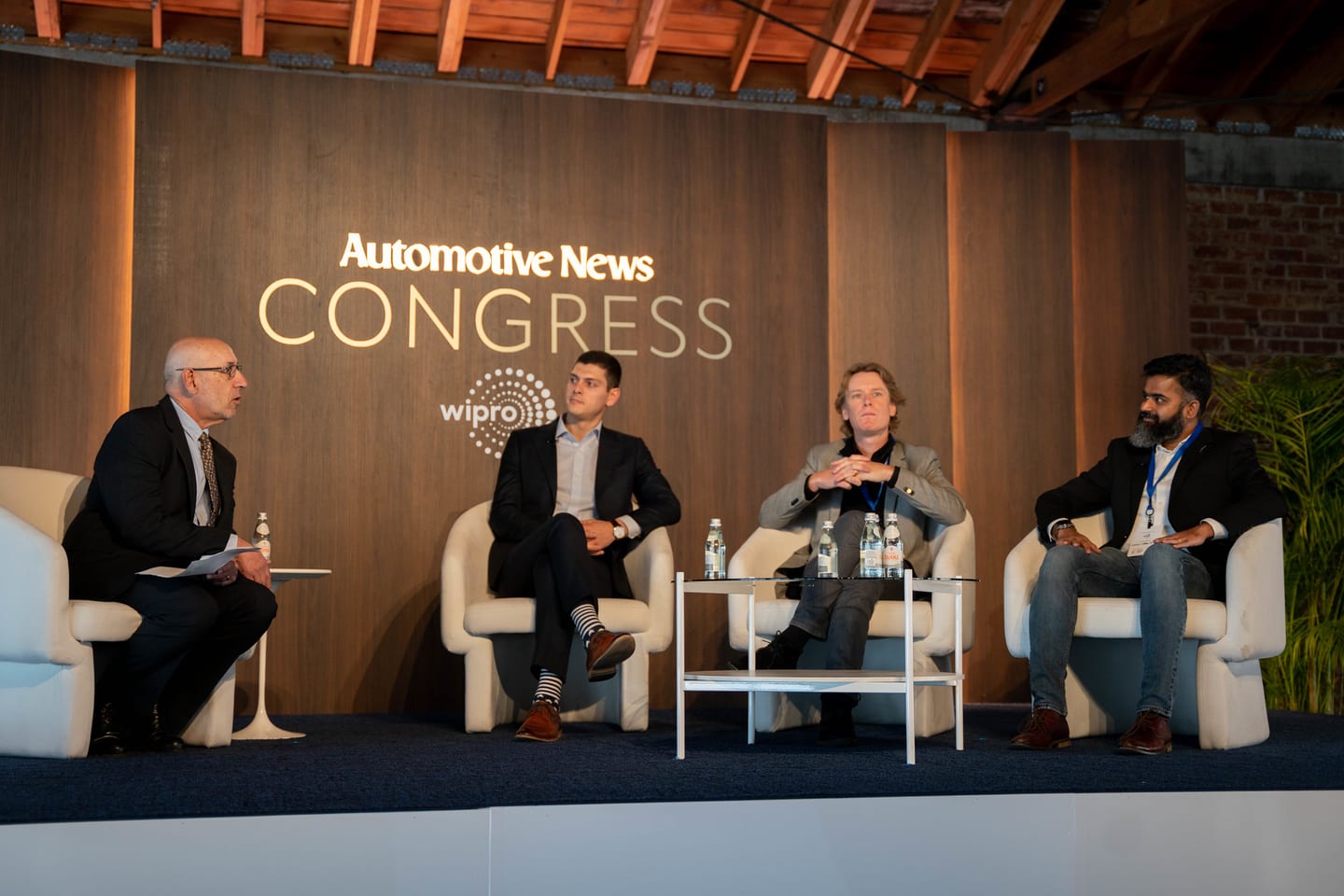 A four-person panel on stage beneath the Automotive News Congress branding at the Automotive News Congress: Los Angeles, City Market Social House