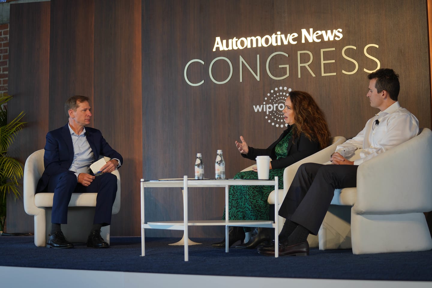 A three-person panel seated beneath the Automotive News Congress and Wipro wall at the Automotive News Congress: Los Angeles, City Market Social House