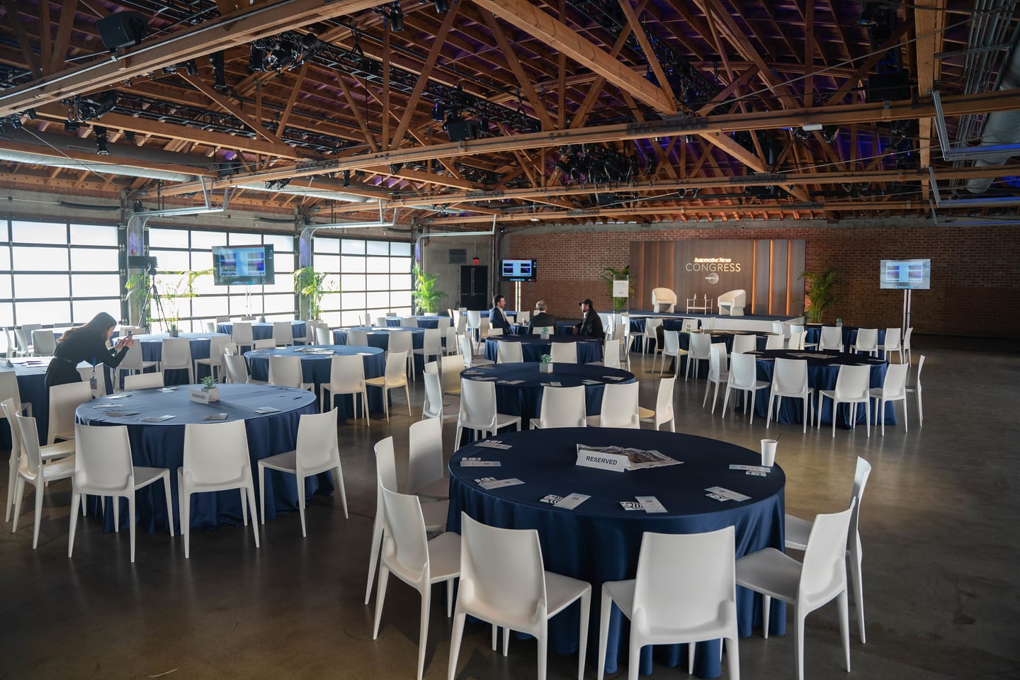 The room set with round tables and white chairs, photographed before attendees arrived at the Automotive News Congress: Los Angeles, City Market Social House