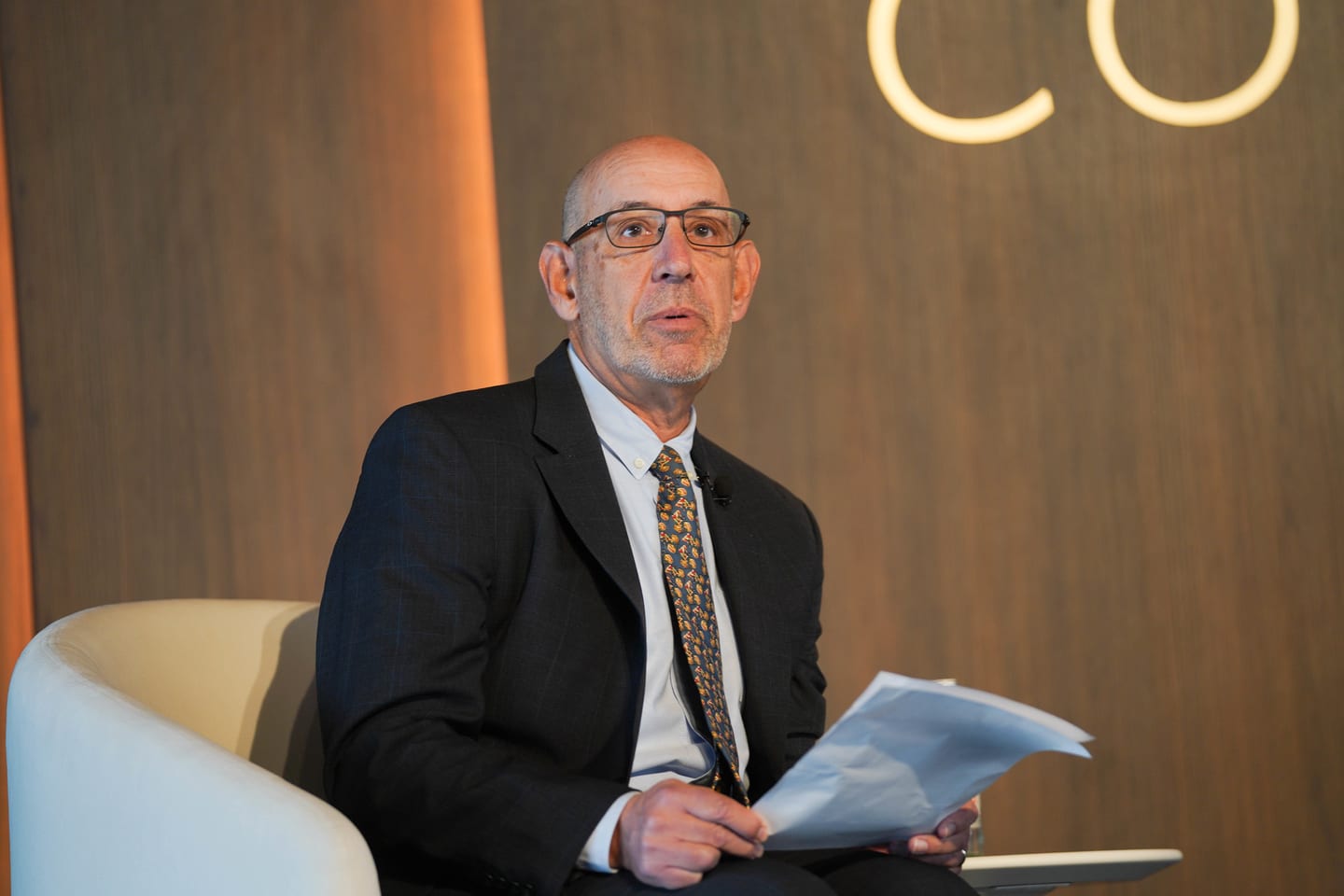 A speaker seated with printed notes before taking the stage at the Automotive News Congress: Los Angeles, City Market Social House