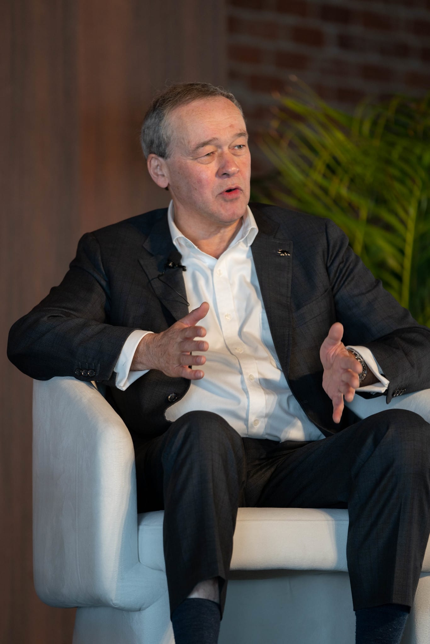 A speaker seated on stage during an interview session at the Automotive News Congress: Los Angeles, City Market Social House