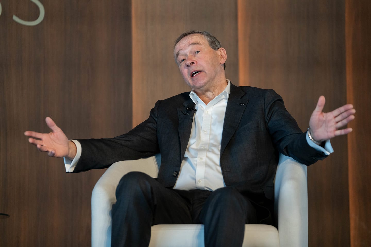 A speaker gesturing with both hands during an on-stage interview at the Automotive News Congress: Los Angeles, City Market Social House