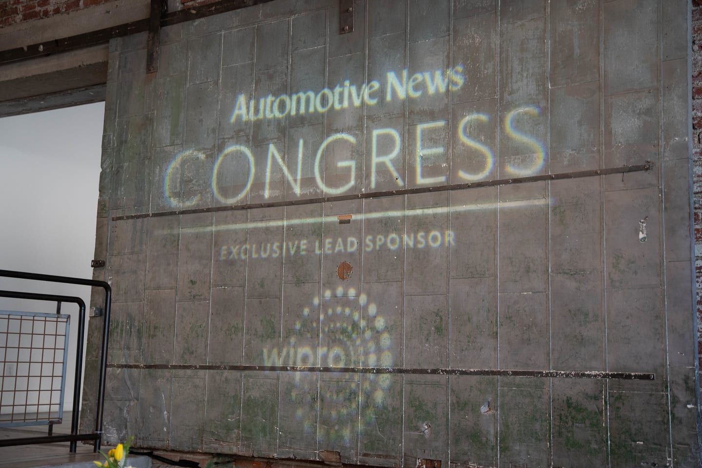 The Automotive News Congress and Wipro exclusive-lead-sponsor logo projected onto the venue’s bare brick wall at the Automotive News Congress: Los Angeles, City Market Social House