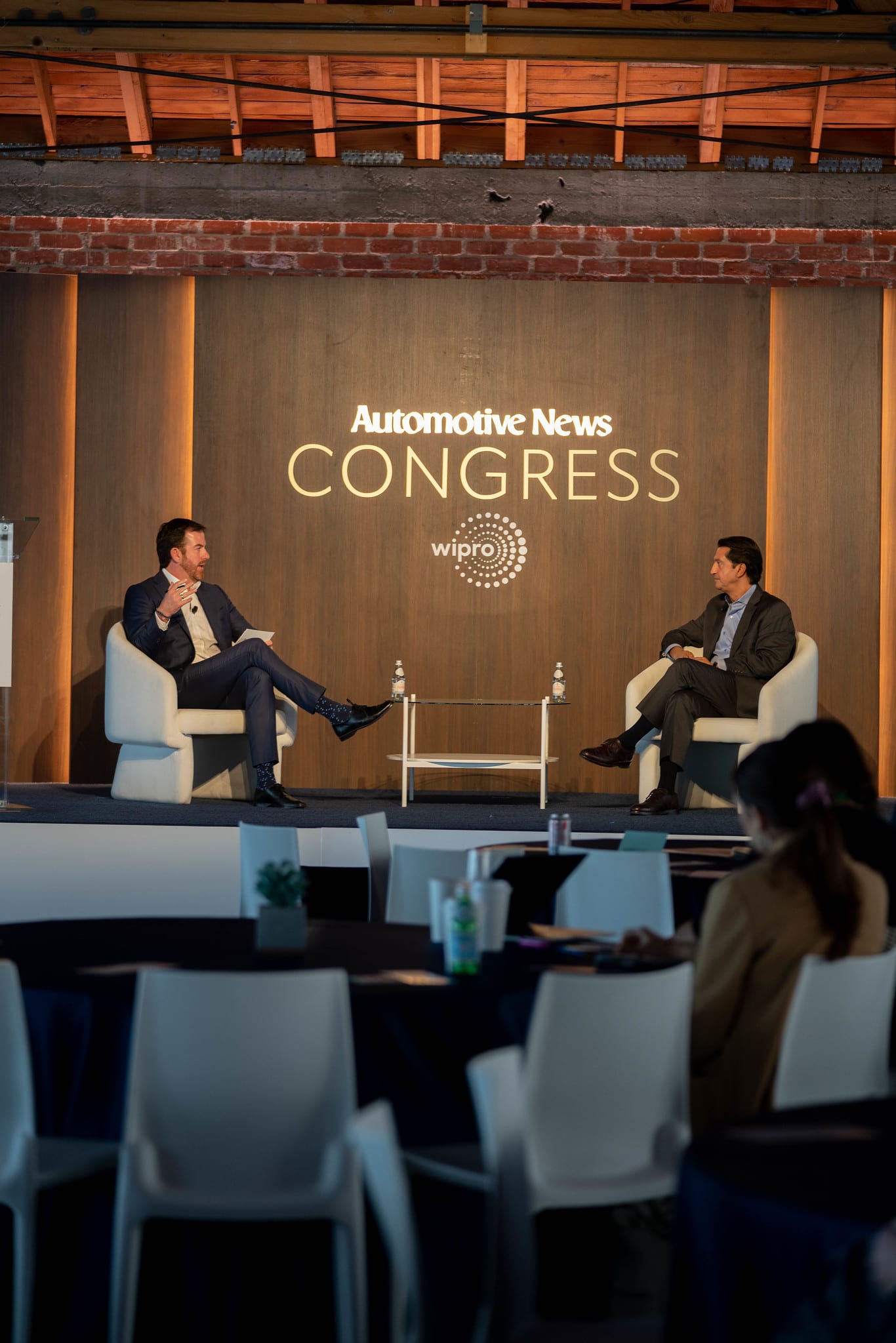 Two speakers seated on stage under the Congress branding at the Automotive News Congress: Los Angeles, City Market Social House