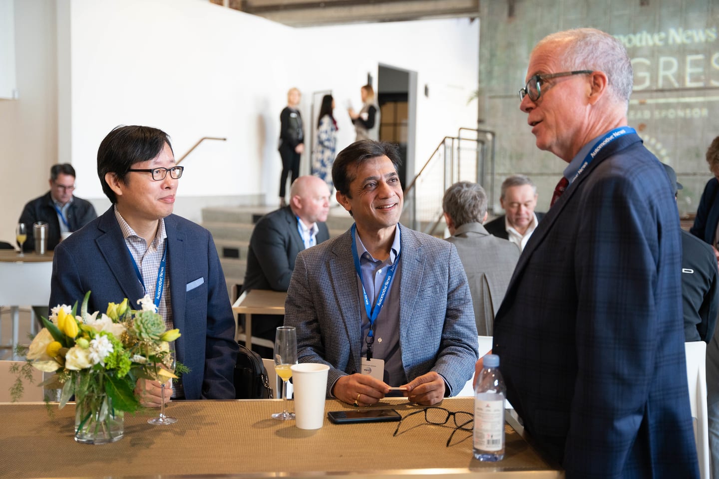Three attendees in conversation at a table during a break at the Automotive News Congress: Los Angeles, City Market Social House