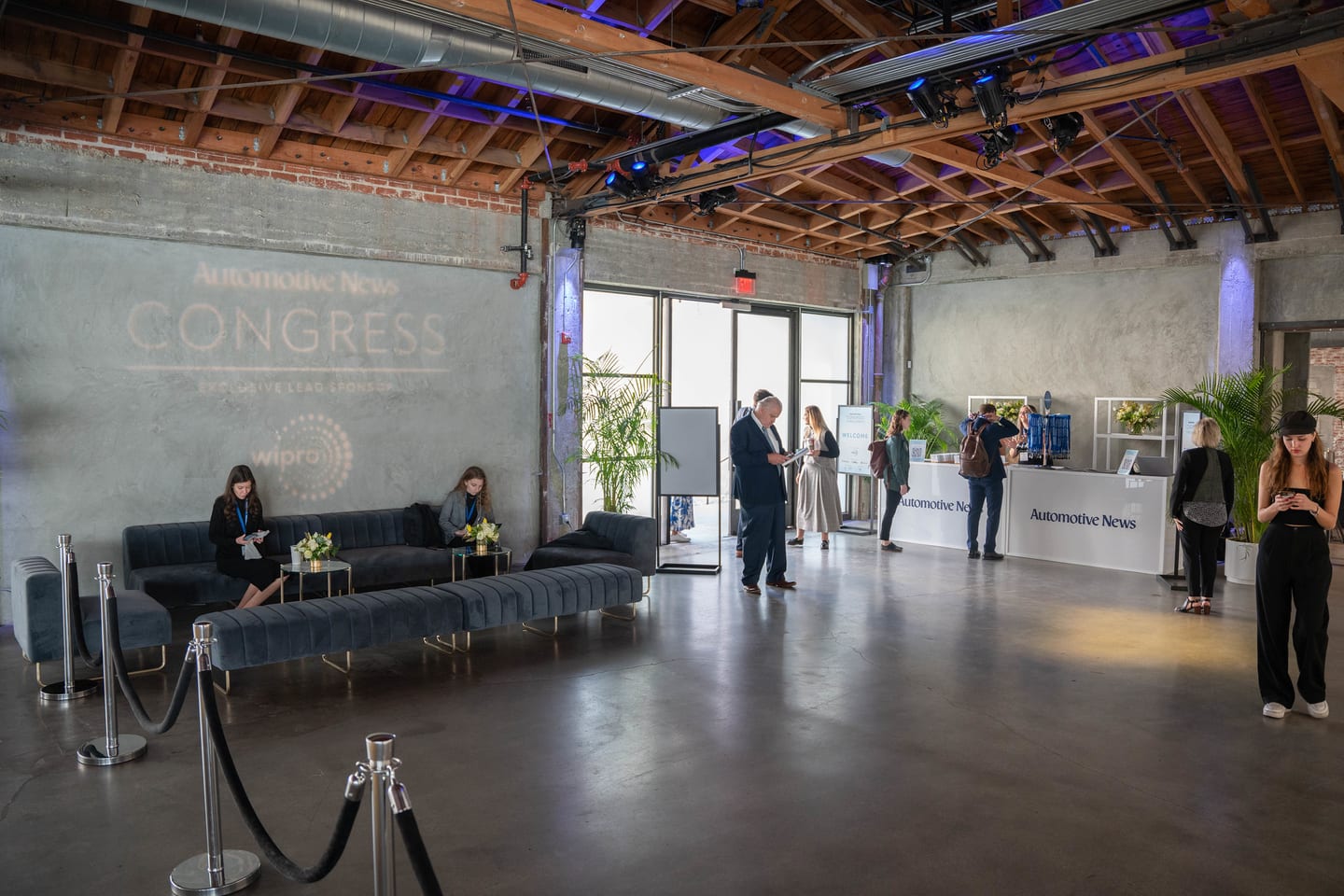 A wide view of the venue lounge and entry with the Congress logo projected on the concrete at the Automotive News Congress: Los Angeles, City Market Social House