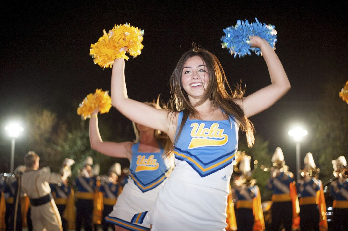 UCLA cheerleader with gold pom-poms at a BuzzFeed brand activation