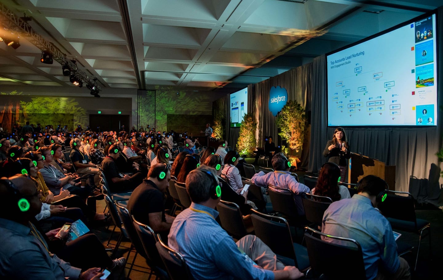 Wide view of the main stage and seated audience at a corporate summit general session