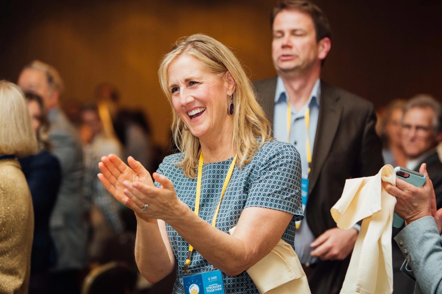 A delegate applauding among the audience during a corporate conference general session