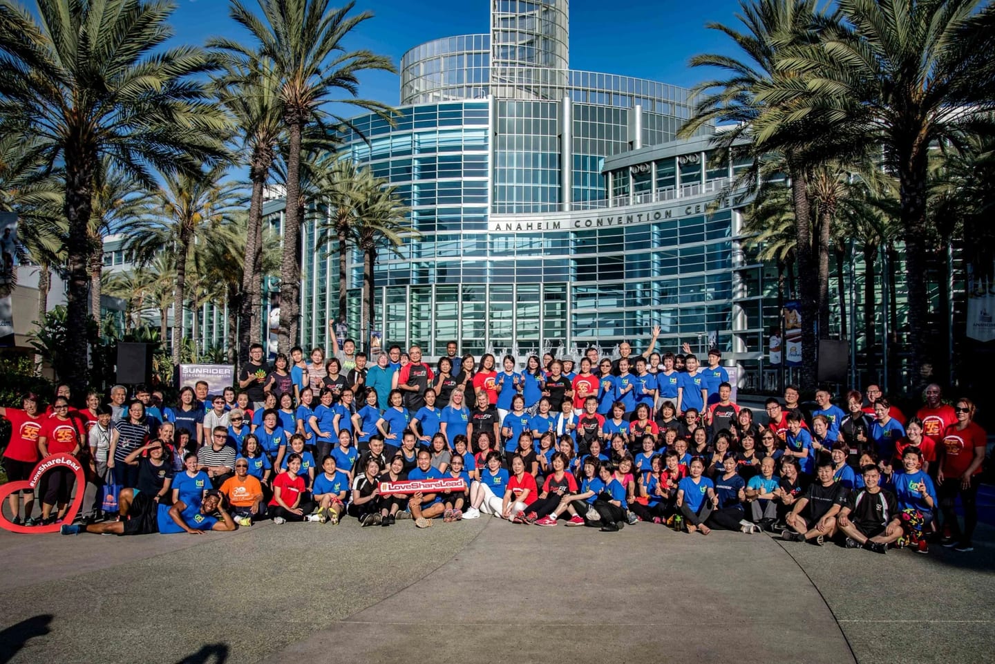 A large all-company group photo outside a convention center in San Diego