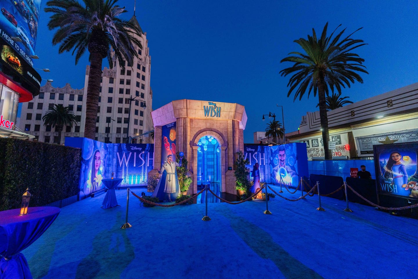Blue-carpet premiere setup for Disney’s Wish on Hollywood Boulevard at dusk