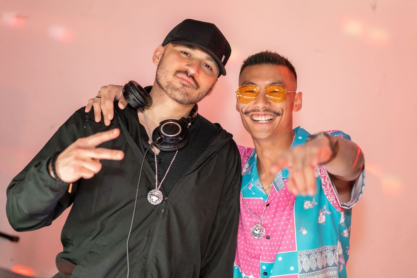 DJ with headphones posing with a friend at an after-party