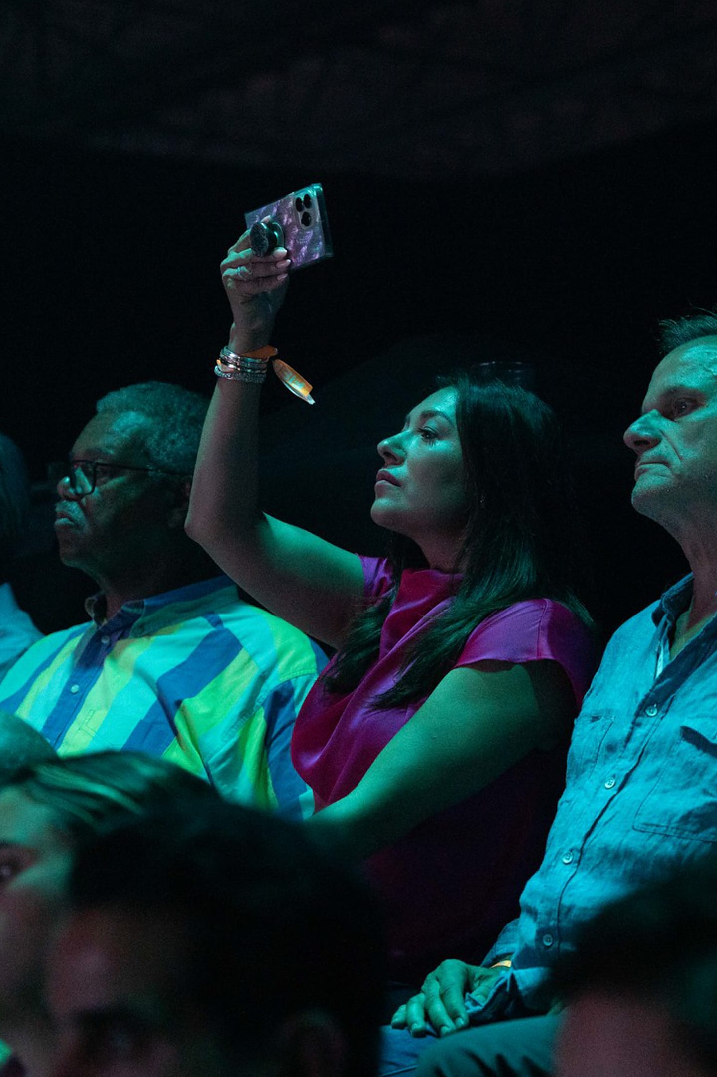 A guest filming the stage on a phone from the audience