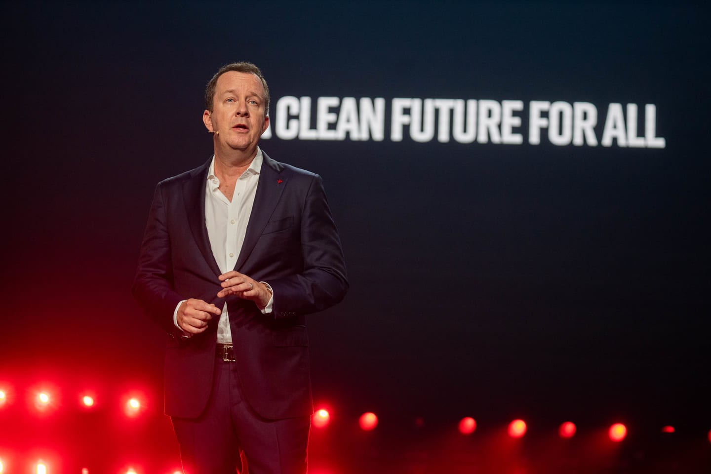 Wide view of a speaker on stage beneath the words Clean Future For All