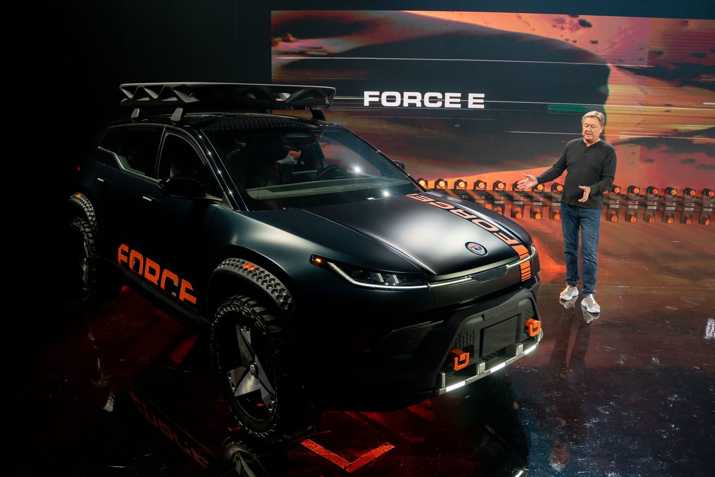 A presenter beside the Fisker Force E under a FORCE E screen