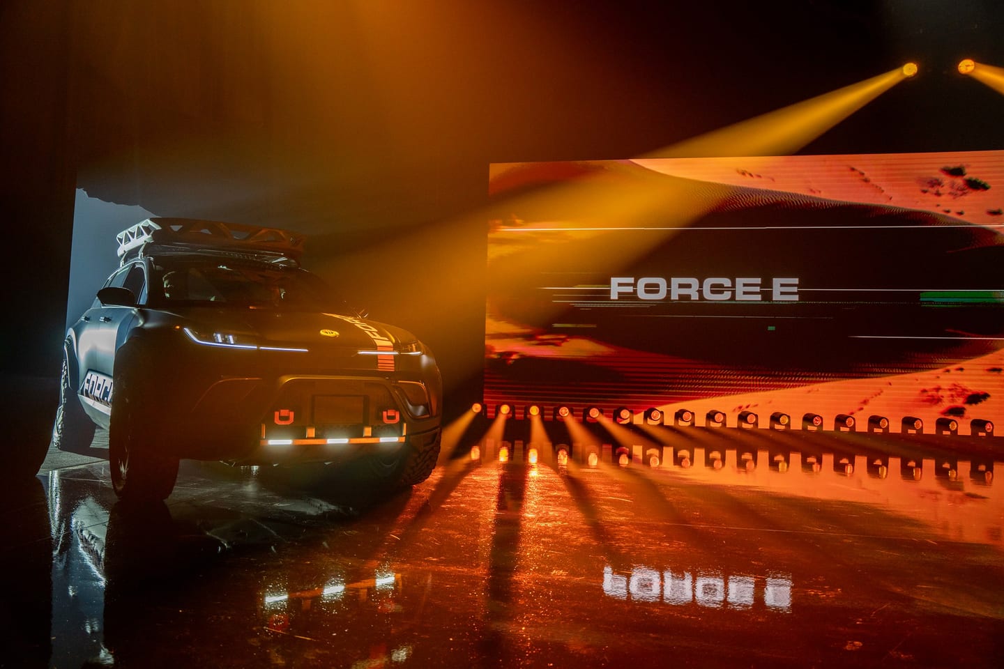 The Fisker Force E on stage with FORCE E across the screen behind