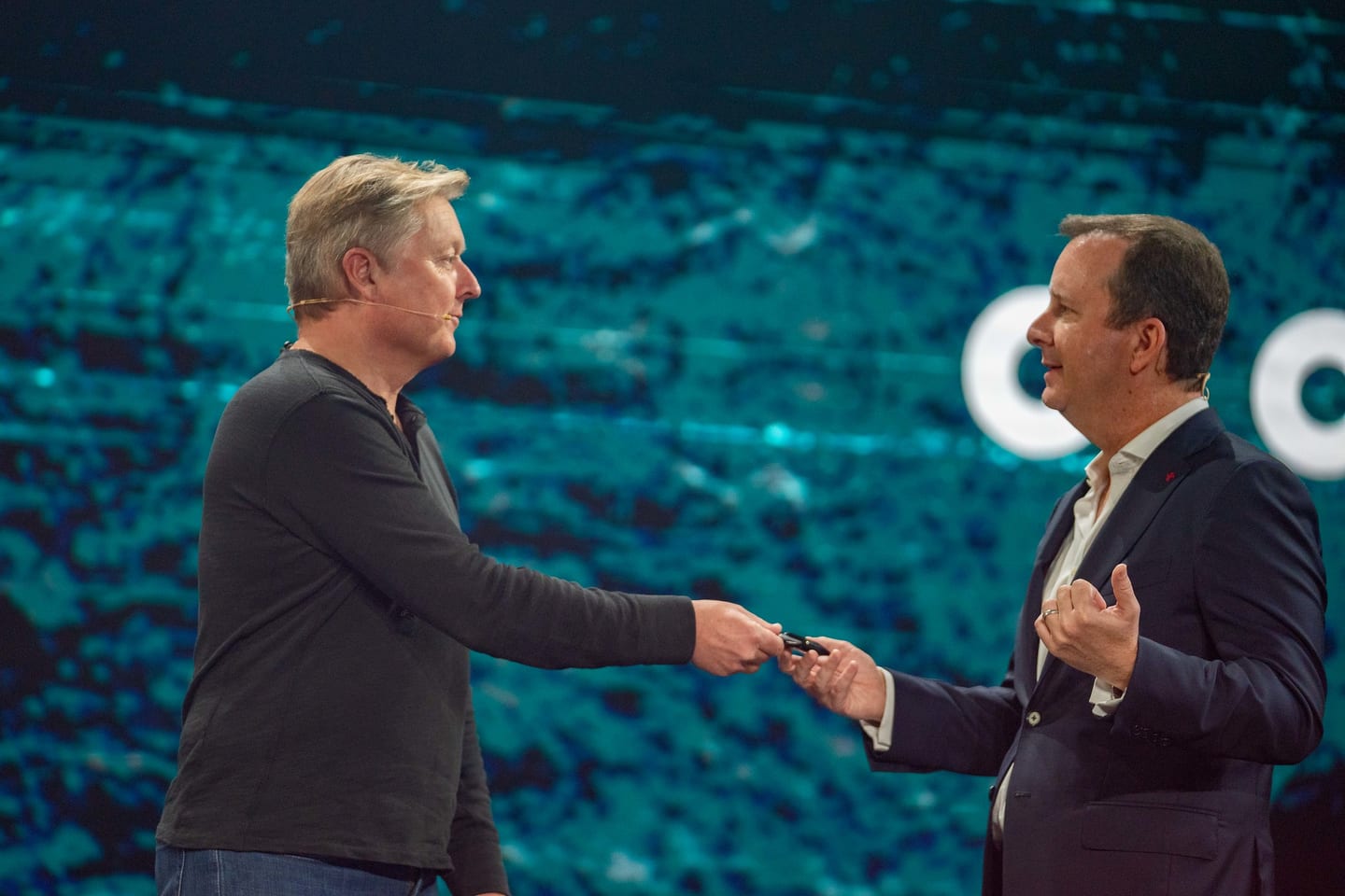 Two speakers shaking hands on stage during the presentation