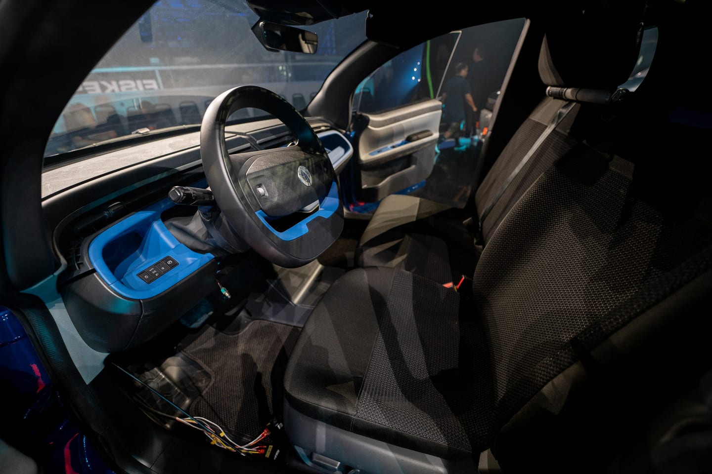 The steering wheel and cabin of a Fisker vehicle with blue interior accents