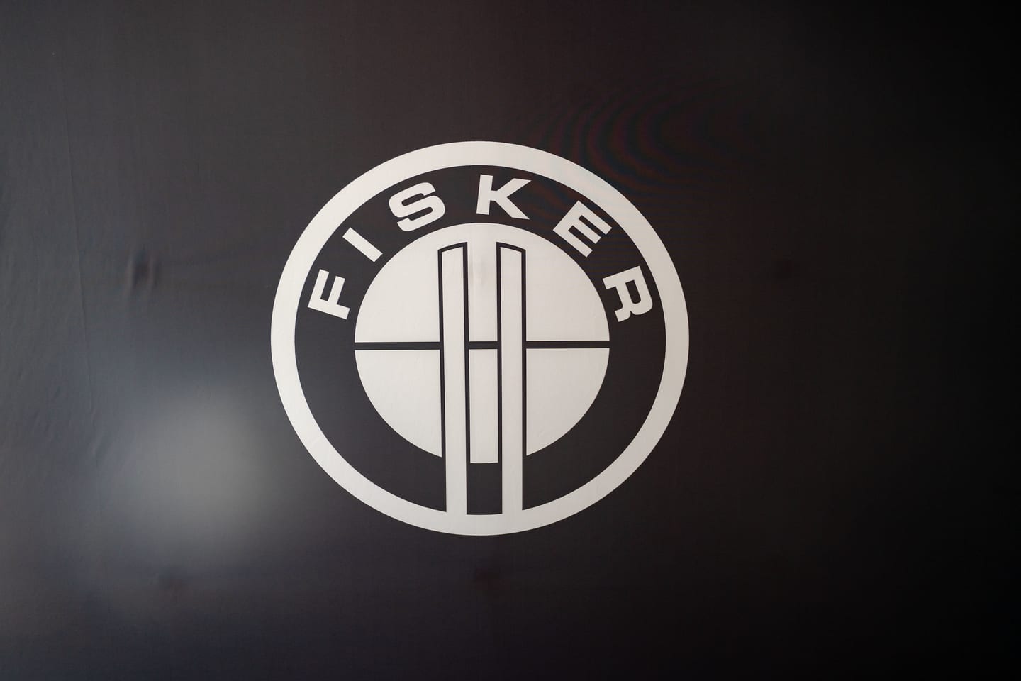 The Fisker roundel logo projected on a dark wall